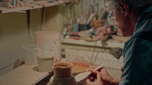 Potter malt den Tonkrug, kreative Dekoration, konzentrierter Künstler, Zeichnungsfläche seines Topfes