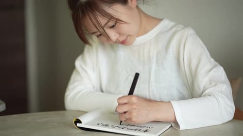 Eine Frau, die mit einem Pinselstift schreibt