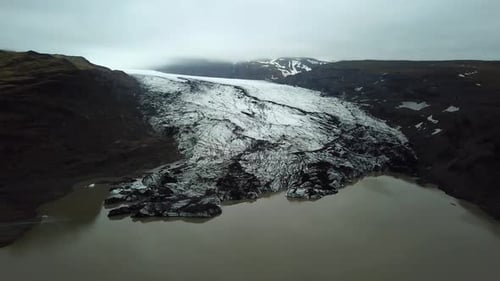 Aerial landscape view over Sólheimajökull glacier, melting into water, in summer, Iceland
