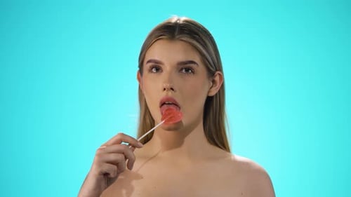 Woman licking red lollipop