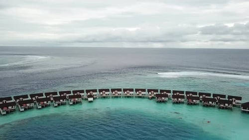 Foto do Panorama Drone do beco de vilas aquáticas em um resort nas Maldivas. Água azul e turquesa. 4K
