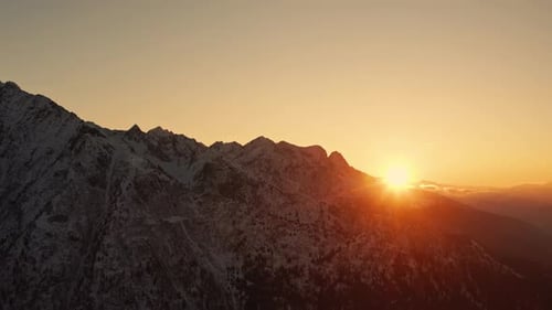 Picturesque Warm Sunset over Italian Alps in wintertime.
Aerial Drone shot of Mountain peak at Golde