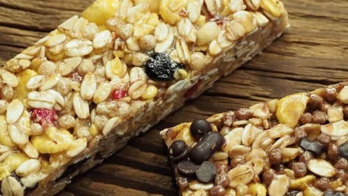 Cereal superfood energy bars with almond nuts, dry fruits, raisins chocolate on the wood table