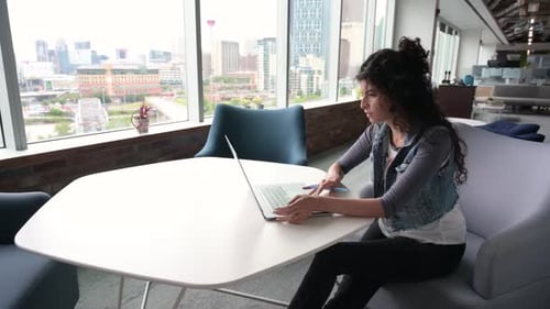 Femme d'affaires travaillant sur un ordinateur portable dans un bureau urbain moderne de 30 à 34 ans