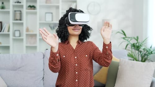 Young successful african american female works using VR glasses in virtual reality simulator sitting