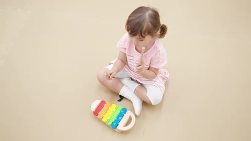 Child Playing on Xylophone Sitting on a Floor at Home - High Angle View