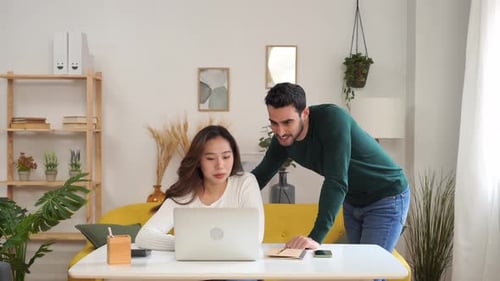 Couple Working Together on Laptop in Home Setting