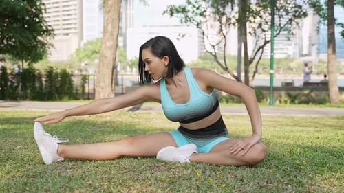 Active Woman Stretching Leg in a Sunny Park