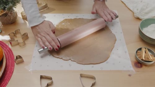 Woman Rolls Dough to Prepare Christmas Cookies