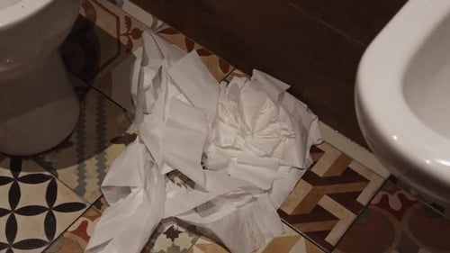 Disorder in a Bathroom Crumpled Tissues on Colorful Tiled Floor Need Cleaning for Hygiene Interior