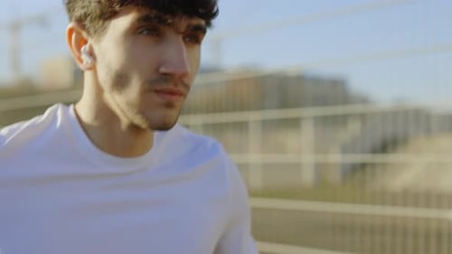 Attractive Bearded Guy Jogger Running on a Modern Urban Stadium