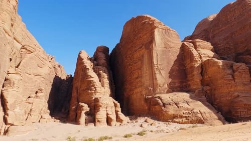 Pan across sandstone and granite towers in Wadi Rum historic site