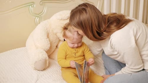 Mother Reading to Baby with Teddy Bear