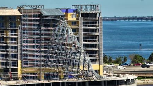 Aerial View of Ruined By Hurricane Ian Construction Scaffolding on High Apartment Building Site in