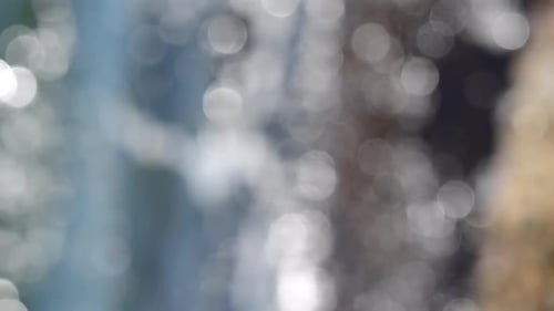 Sea Waves Rolling Crashing Rocks Lots of White Bokeh Spots of Sun Glare Vertical