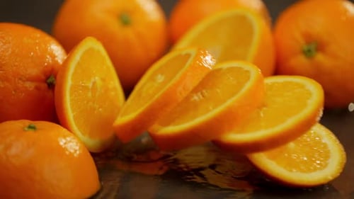 In the Closeup an Orange Falls and Scatters Into Round Pieces