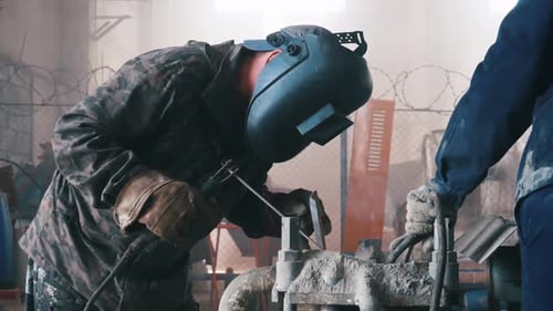 Industrial Worker Welding Metal in a Factory