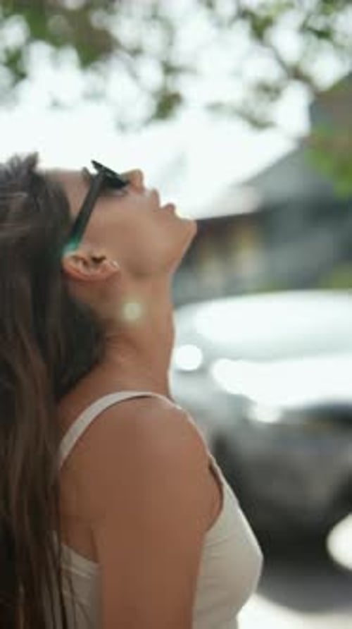 A Woman in Sunglasses Walking Casually in a Park