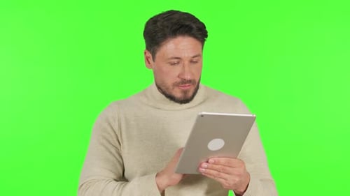 Middle Aged Man Using Digital Tablet on Green Background