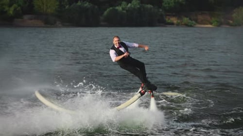 Un hombre de traje realiza trucos en una tabla de flyboard