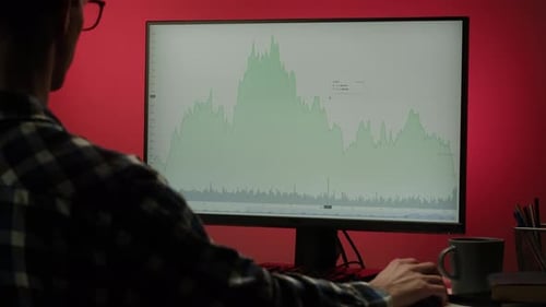 Man Tracking Stock Chart with Pen at Desk