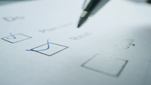 Person Ticks Checkbox Marks with a Pen, filling up To Do List. Checking Marks and FIlling in a Task