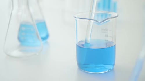 Blaue Chemikalie im Becher umrühren