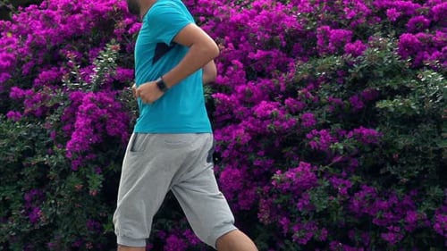 Young man jogging alone in city park super slow motion