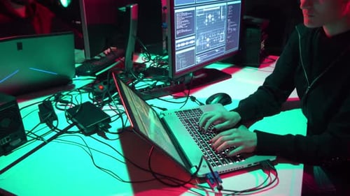 Woman Typing Code on Laptop in Dark Office