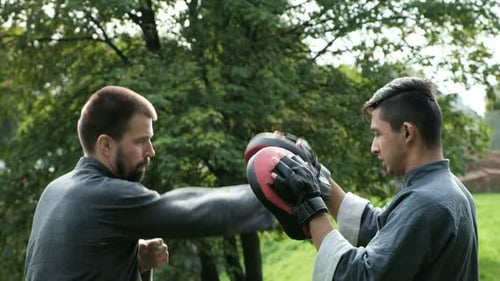 Two men practicing martial arts in urban park