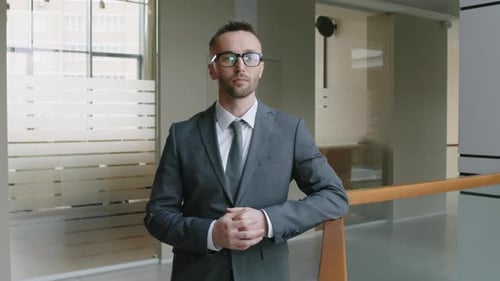 Portrait of Serious Businessman Standing in Office Foyer