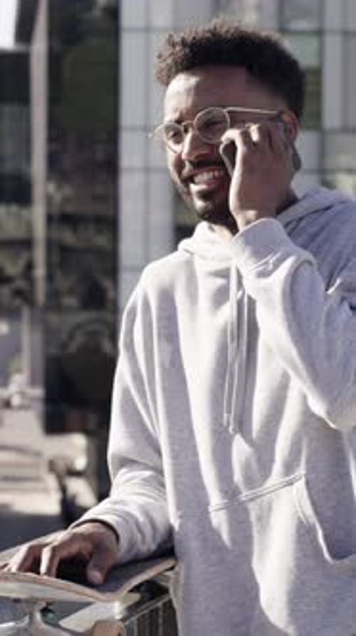 Happy, man and skateboard in city with phone call, connection and discussion for training feedback