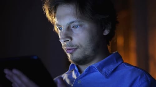 4k video footage of a young businessman using his digital tablet at night at home