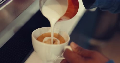 Coffee, milk and hands of person in cafe for beverage, breakfast and espresso