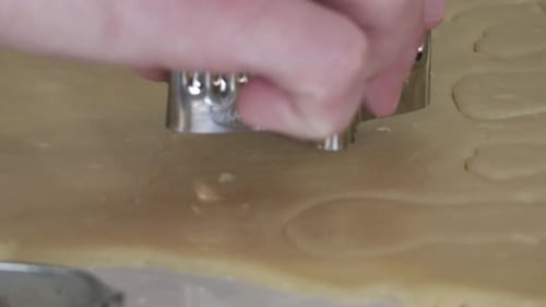 Cookie Cutter Cuts Cookie Dough in Kitchen Close-up