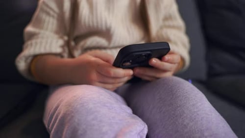 Young Child Using Smartphone on Couch Indoors