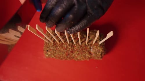 Top view of cook slicing a rolled beef seasoned with spices.