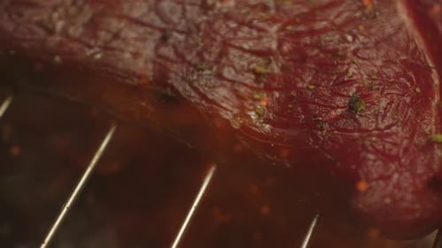 Grilled Meat Steak on Stainless Grill Depot with Fire on Dark Background Preparing Tasty Raw Red