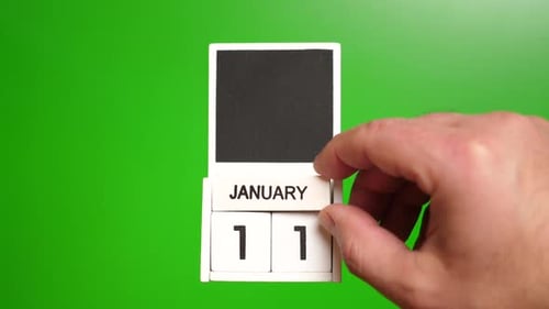 Hand Flips Calendar to January 11 on Green
