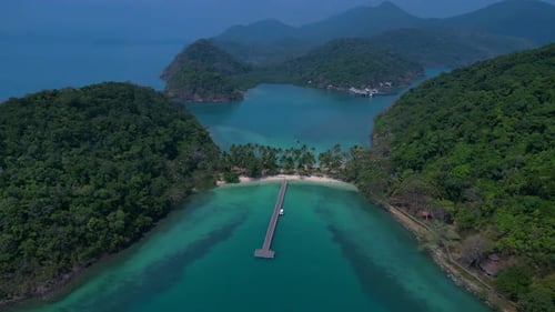 Island with pier leading to tropical beach. Beautiful aerial view flight drone