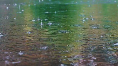 Las gotas de lluvia caen sobre la superficie del río con burbujas en verano