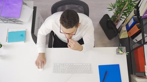 Tired businessman works in office and is overwhelmed.