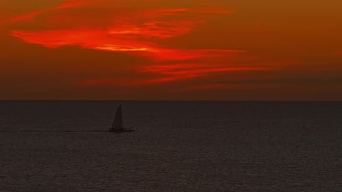 Sailboat Cruising In The Ocean At Dusk In Dominicus Beach, Bayahibe, Dominican Republic. - wide shot