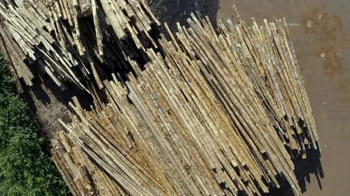 Top down aerial view of impressive pile of wooden logs at a lumber yard