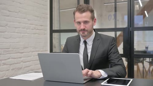 Professional Man Working on Laptop Giving Thumbs Up