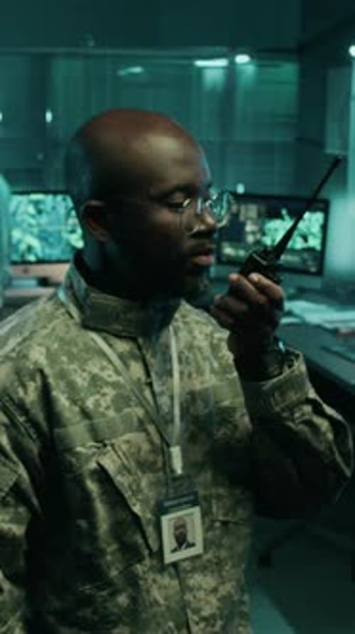 Black Army Officer Transmitting Target Coordinates on Radio in Command Center