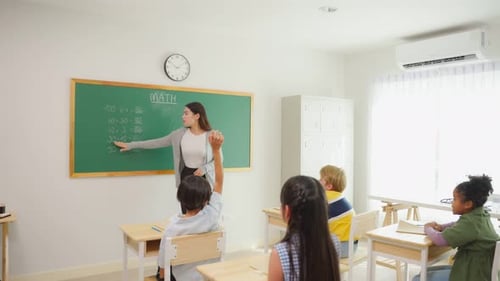 Group of student learn with teacher in classroom at elementary school.
