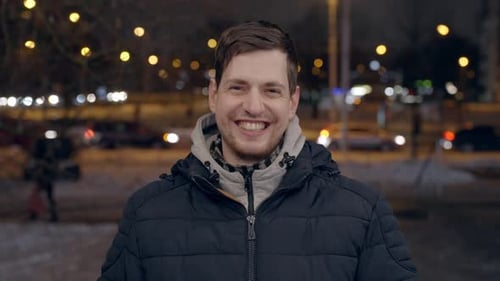 happy caucasian male in 30s laughing and smiling facing camera outdoors in the city