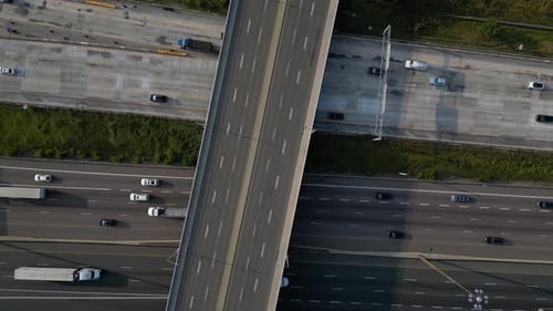 Top down of freeway road construction with trucks and cars driving on multi-level highway
