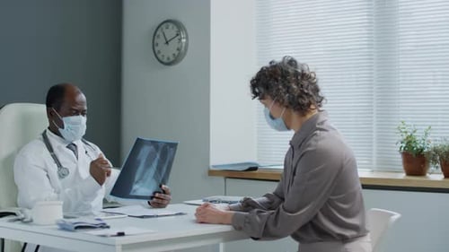 Physician Examining X-Ray with Patient in Medical Office